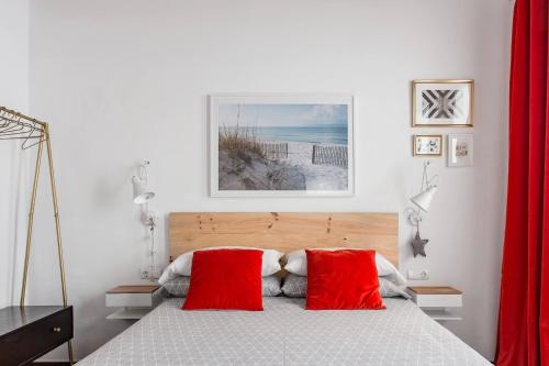 a bedroom with a bed with two red pillows at Stylish Apartment with Terrace for Couple or Family in Barcelona