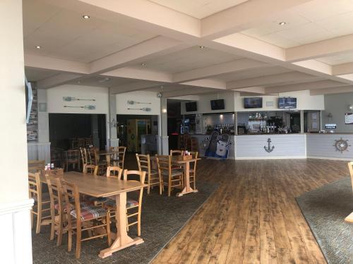 a dining room with wooden tables and chairs at Cockleshell Chalet in Kidwelly