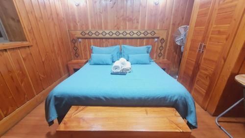 - une chambre avec un lit et une couette bleue dans l'établissement Hostal, à Villarrica