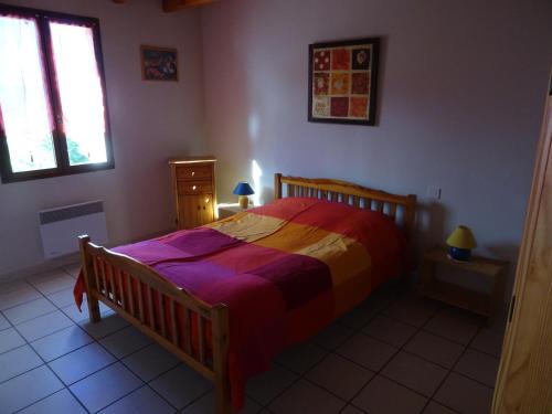 una camera da letto con un letto con una coperta colorata di Le Massif des Ecrins a Les Clots