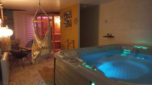 a jacuzzi tub in a room with a hammock at Les pieds dans l'eau... au chaud !!! in Le Crotoy