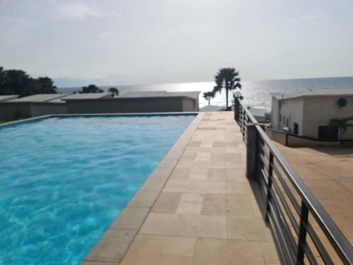 een zwembad met blauw water voor een gebouw bij Relax Serviced Ocean 3bedroom Beach Front House in Bijilo