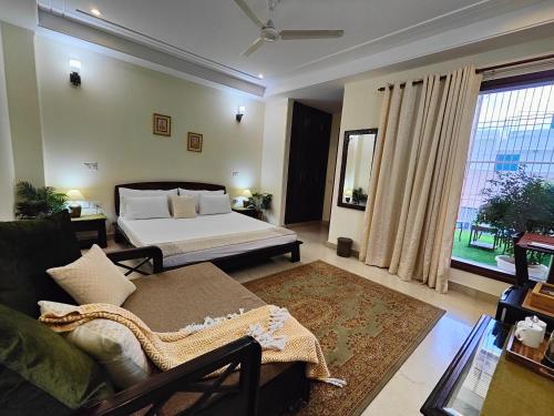 sala de estar con cama y sofá en Niro GK2, en Nueva Delhi