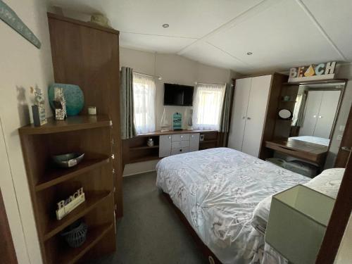 Dormitorio pequeño con cama y vestidor en Ladram Bay Holiday Park D54 en Otterton
