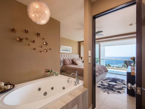 a large bathroom with a tub and a bedroom at Modern- Renovated- Breathtaking 6th Floor- 3 Bedrooms Villa Magna in Nuevo Vallarta 