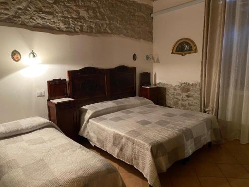 a bedroom with two beds and a stone wall at Masseria La Guardata in Guglionesi