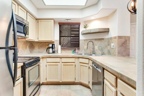 a kitchen with wooden cabinets and a sink at Canyon Crest Condo in Tucson