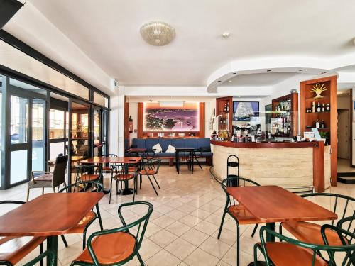 カットーリカにあるHotel La Plageのテーブルと椅子のあるレストラン、バー