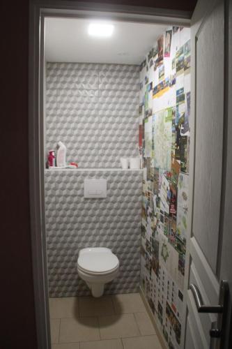 une salle de bain avec toilettes et un mur carrelé dans l'établissement Gîte le Corbeau, à Girondelle