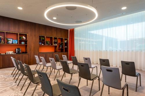a conference room with chairs and a large window at Mövenpick Hotel Stuttgart Messe & Congress in Stuttgart
