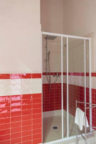 a bathroom with a shower with red and white tiles at La Dispensa-bio agriturismo in Lamporecchio
