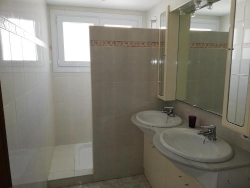 Baño con 2 lavabos, espejo y ventana en Global Immo 3003 Europa, en Roses