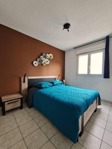 une chambre avec un lit bleu et une fenêtre dans l'établissement L'écrin urbain Centre Ville-Parking Gratuit, à Montpellier