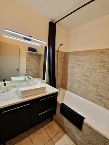 une salle de bain avec un lavabo et une baignoire dans l'établissement L'écrin urbain Centre Ville-Parking Gratuit, à Montpellier