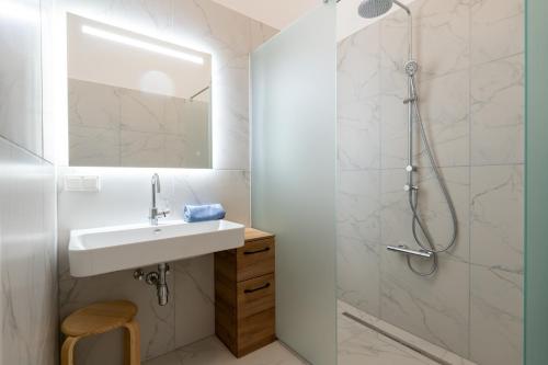een badkamer met een wastafel en een douche bij Pension Pannonia in Parndorf
