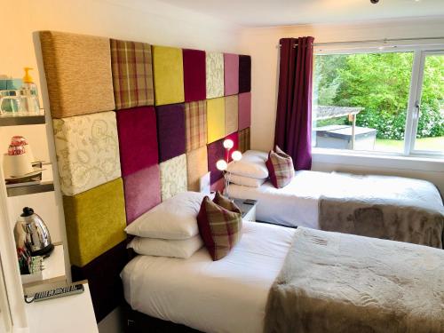 a hotel room with two beds and a window at Distant Hills Guest House in Spean Bridge