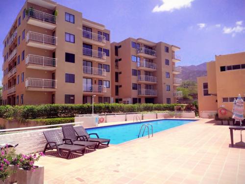uma piscina em frente a um edifício em HERMOSO Apartamento con piscina y cerca a PLAYA. em Santa Marta