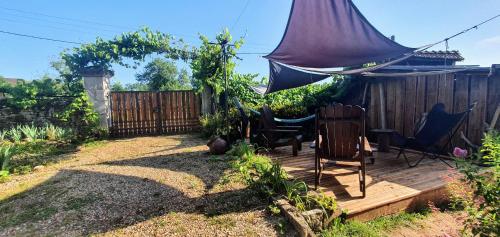 a backyard with a wooden deck with chairs and a tent at Le Loft de l'auberge du Lac Noir in Saint-Cernin-de-Larche