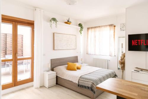 una camera da letto con un letto con cuscini gialli di LOFT con Terrazzo - 3 min dalle Autostrade By followgreenhouserome a Roma