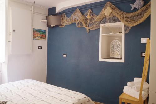 a bedroom with a blue wall with a bed at Ca Du Grifun in Vernazza