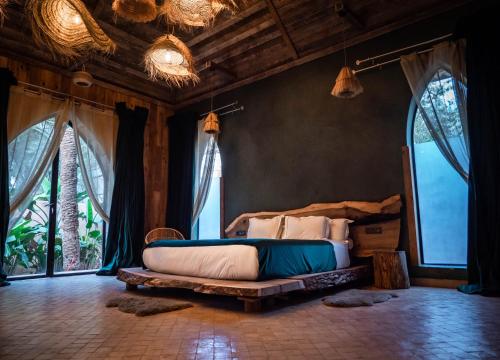 Lodge K في مراكش: غرفة نوم مع سرير في غرفة مع نوافذ