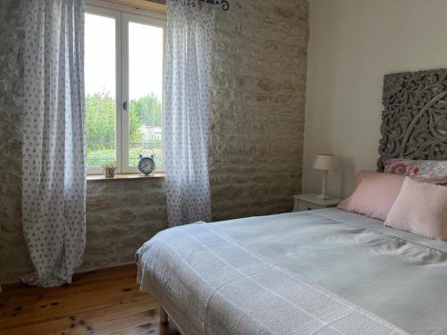 a bedroom with a large bed and a window at La Belle Parenthèse in Vergné