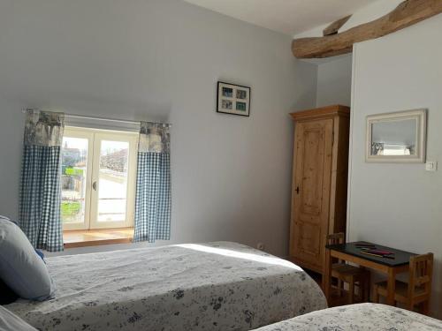 a bedroom with two beds and a window at La Belle Parenthèse in Vergné