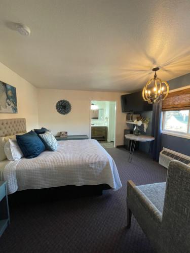 Hagerman Valley Inn في Hagerman: غرفة نوم بسرير ومخدات زرقاء وكرسي