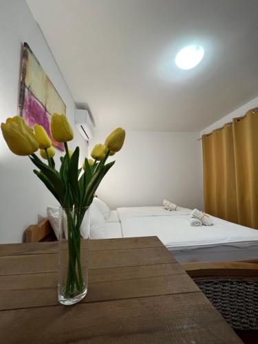 a vase of yellow flowers sitting on a table in a room at Villa Klara in Novi Sad