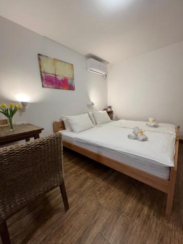Un dormitorio con una gran cama blanca y una mesa en Villa Klara, en Novi Sad
