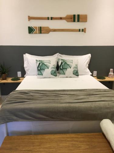 um quarto com uma cama grande com lençóis brancos e almofadas em Sua casinha de férias em Icapui CE em Icapuí