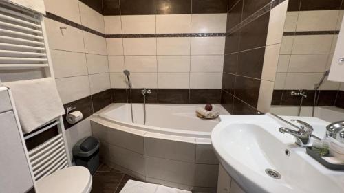 a bathroom with a tub and a sink and a toilet at Wellness penzion U Grygarů in Lipník nad Bečvou