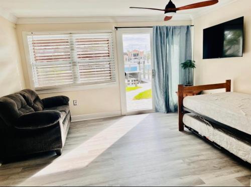 1 dormitorio con cama, sofá y ventana en Cheerful home with one bedroom en Cape Coral