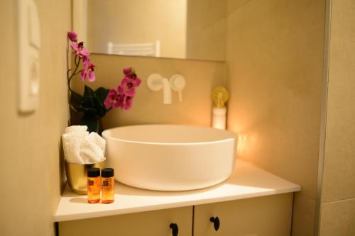 La salle de bains est pourvue d'un lavabo et de fleurs sur un comptoir. dans l'établissement Balinese Cityflat AC, à Anvers