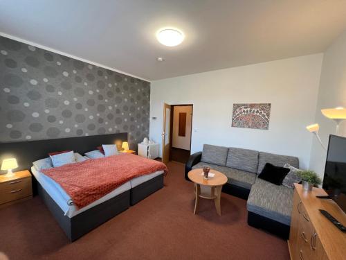 a bedroom with a bed and a couch at Wellness penzion U Grygarů in Lipník nad Bečvou