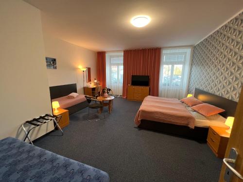 a hotel room with two beds and a tv at Wellness penzion U Grygarů in Lipník nad Bečvou