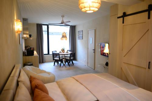 ein Schlafzimmer mit einem Bett und ein Wohnzimmer mit einem Tisch in der Unterkunft Balinese Cityflat AC in Antwerpen