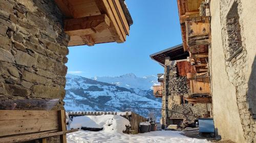 a view from an alley in a village in the snow at Bourg Saint Maurice Les Arcs - maisonnette grand confort dans charmant village de montagne ! in Bourg-Saint-Maurice
