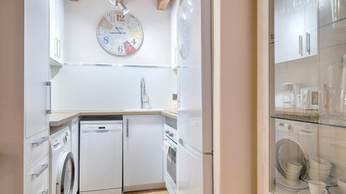 una cocina con electrodomésticos blancos y un reloj en la pared en Saplan Real Estate CARLAC, en Les