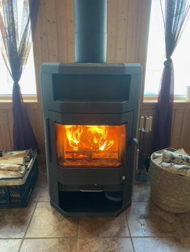 a stove with a fire in it in a room at Camping Fredrika-Braber in Fredrika