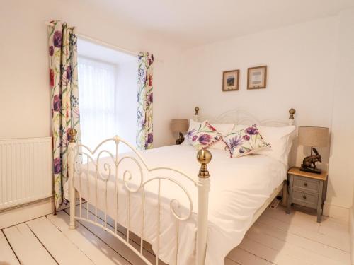 Un dormitorio con una cama blanca y una ventana. en Trigfa, en Blaenau Ffestiniog