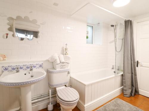 a bathroom with a sink and a toilet and a tub at Trigfa in Blaenau-Ffestiniog
