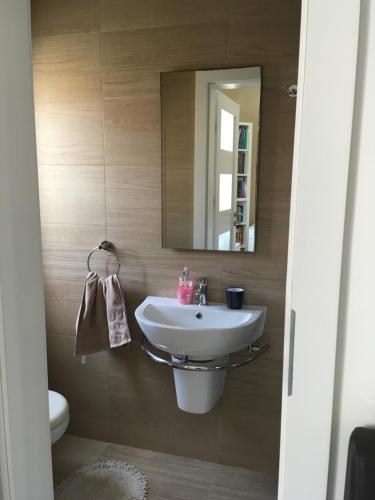 La salle de bains est pourvue d'un lavabo et d'un miroir. dans l'établissement Pembroke Suites, à Pembroke
