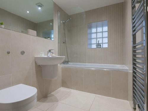 a bathroom with a sink and a toilet and a tub at Atlantis in St Ives