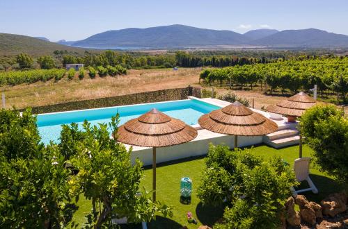 una imagen de una piscina con sombrillas en Residenza alla Collina & Romantic SPA en Porto Conte