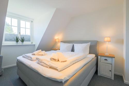 ein Schlafzimmer mit einem Bett mit zwei Handtüchern darauf in der Unterkunft Drutenhüs in Wenningstedt-Braderup