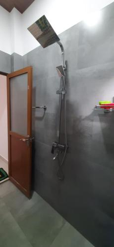 baño con ducha con una luz en la pared en Family Time Holiday Home, en Anuradhapura