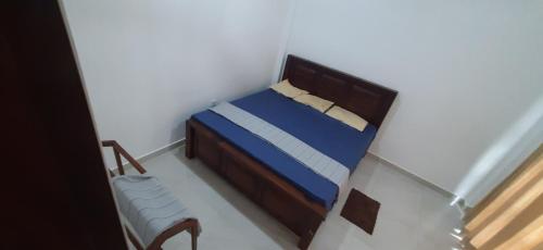 a small bedroom with a bed and a chair at Family Time Holiday Home in Anuradhapura