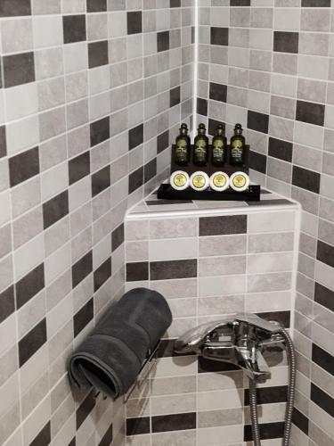 a tiled bathroom with a shelf with bottles on it at Vasiliki Villa in Orthés