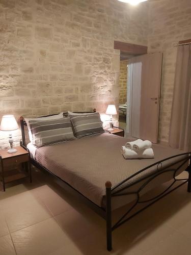 a bedroom with a large bed with two lamps on tables at Vasiliki Villa in Orthés